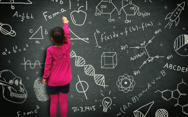 Child writing equations on blackboard